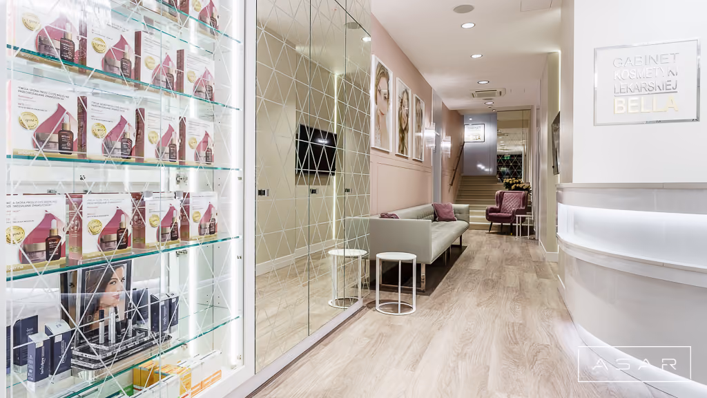 Korytarz Kliniki Bella z przeszkloną ekspozycją produktów i jasną aranżacją wnętrza – ASAR Projekt