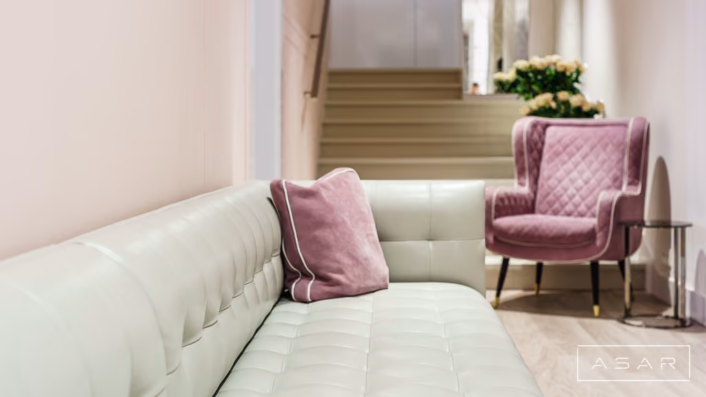 Poczekalnia Kliniki Bella z jasną sofą, różowymi fotelami i pastelowymi dodatkami – ASAR Projekt
