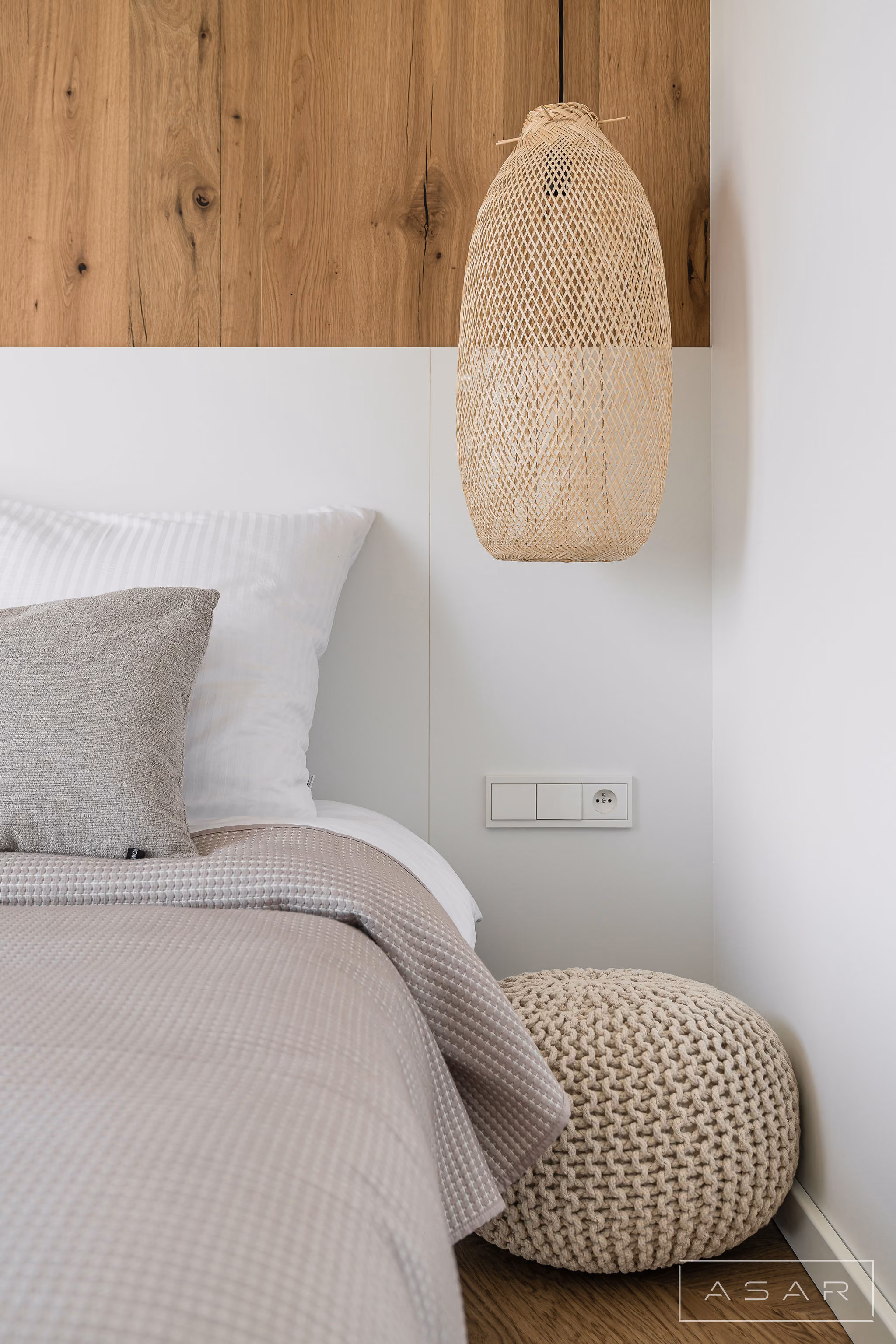 Detal sypialni apartamentu nad morzem z drewnianą ścianą i dekoracyjną lampą – ASAR Projekt