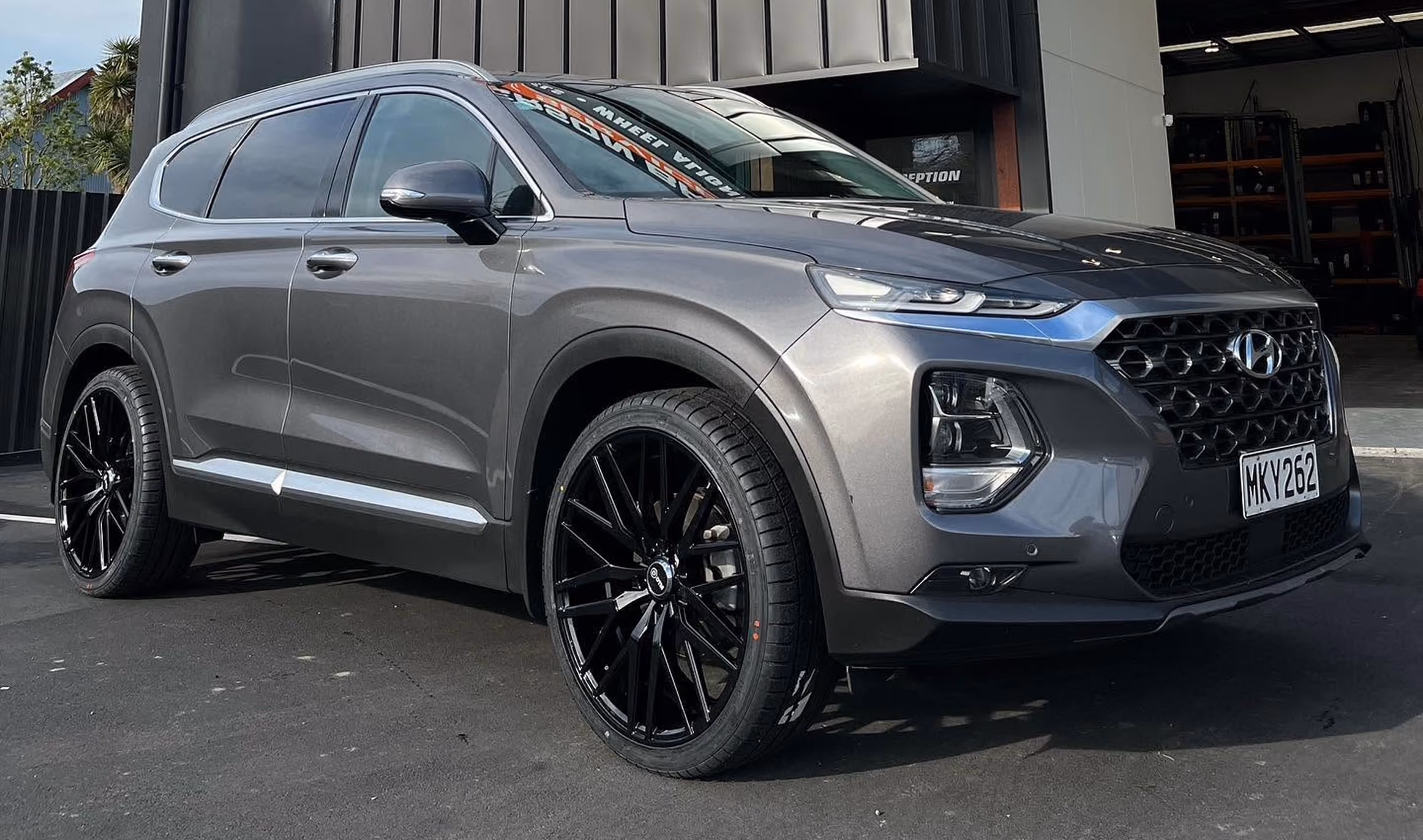 Gray Hyundai SUV parked outside a building with black wheels and a visible license plate MKY262.