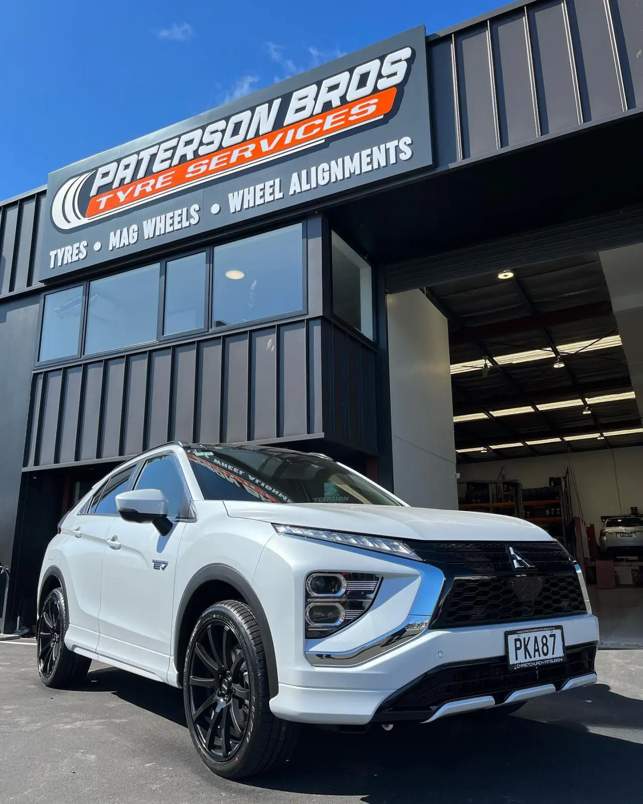 White Mitsubishi Eclipse Cross parked outside Paterson Bros Tyre Services with black mag wheels.