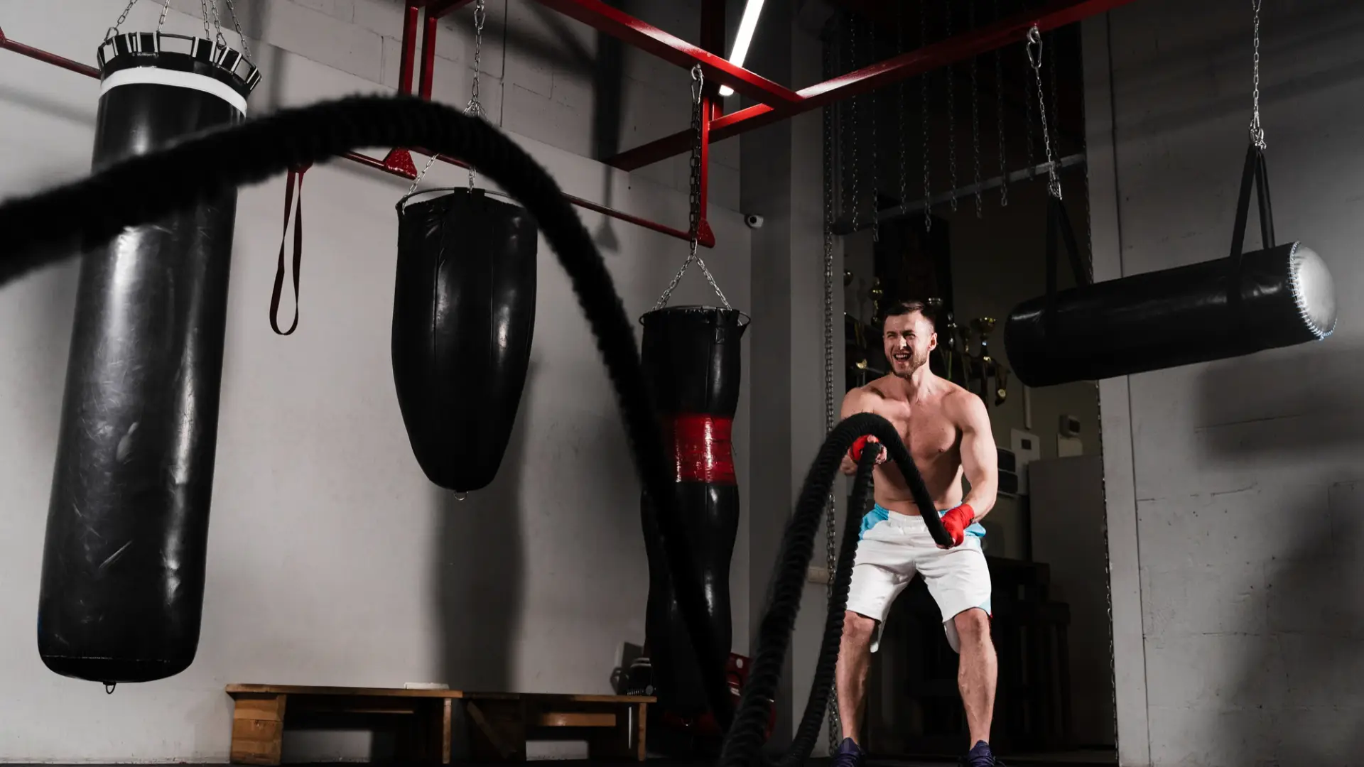 a man practicing with a rope surrounded by training bags