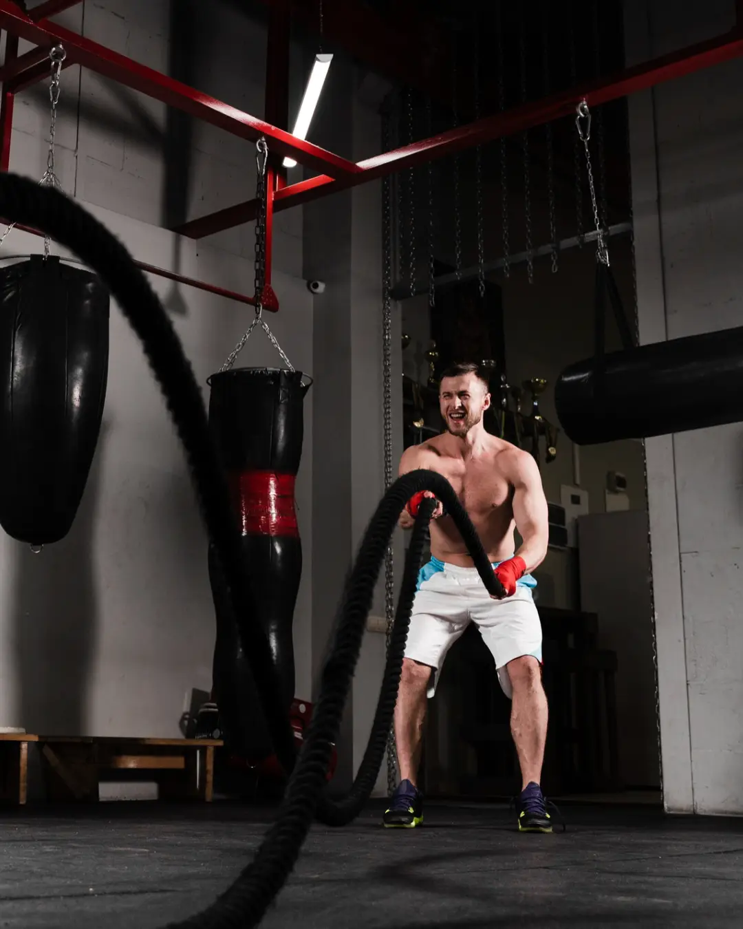 a man practicing with a rope surroundedby training bags