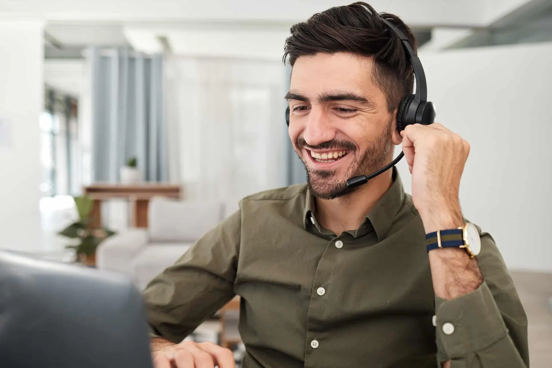Man, remote work and virtual assistant with headphones at laptop for video call, voip communication