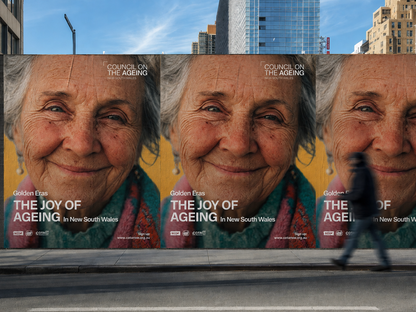 Three large posters on a city wall showing a close-up of an elderly woman with white hair wearing a colorful scarf and smiling, promoting 'Golden Eras THE JOY OF AGEING In New South Wales' by the Council on the Ageing New South Wales, with a blurred person walking in front.