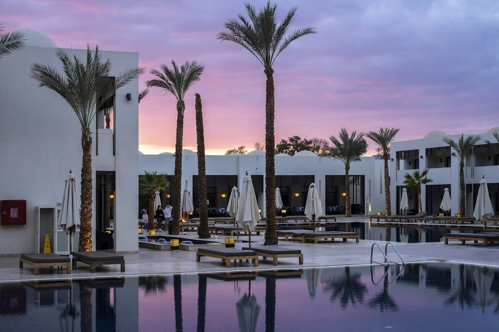 Piscine bordée de palmiers au crépuscule