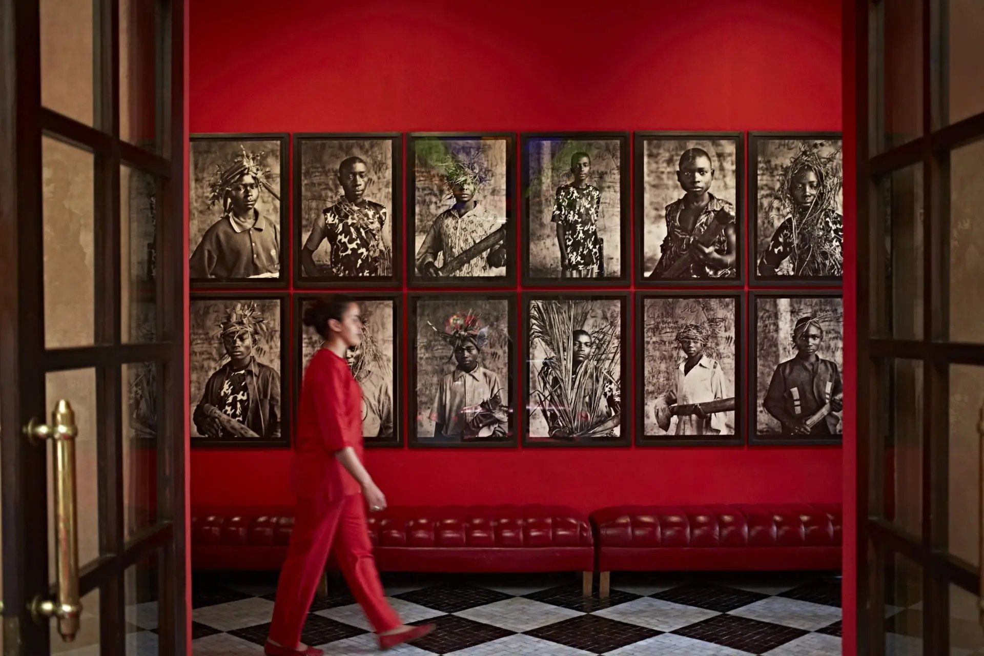 Œuvres d'art exposées sur un grand mur rouge. El Fenn, Marrakech.