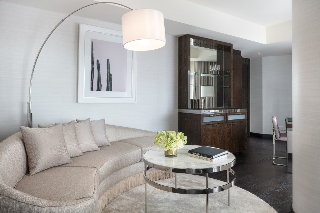 Strip Suite, salon courbe aux tons clairs et table basse ; Waldorf Astoria Las Vegas, Las Vegas.