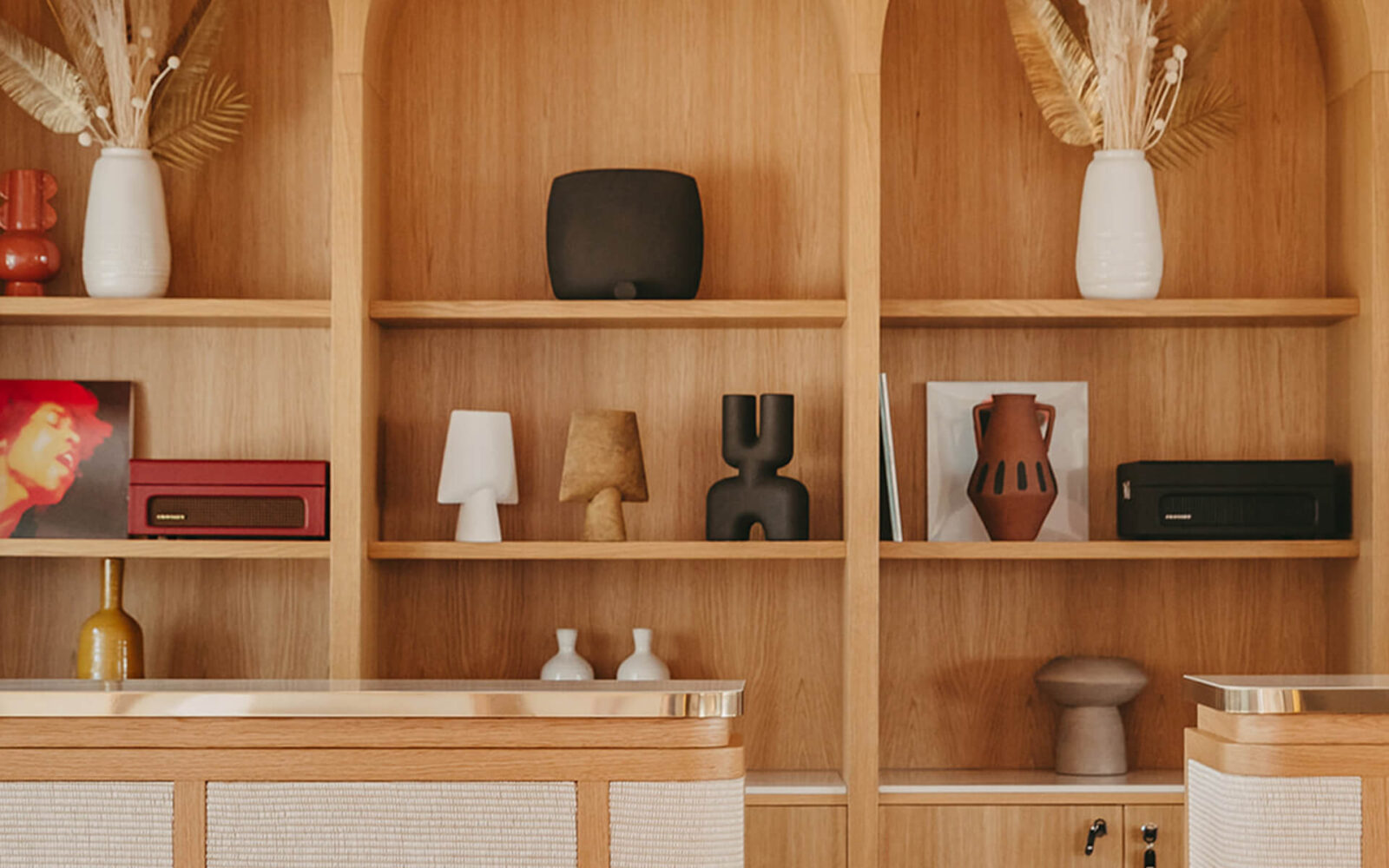 Comptoir de réception du Riomar, devant une bibliothèque en bois et des objets décoratifs.