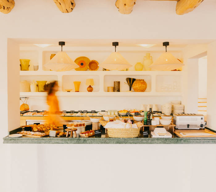Buffet du petit déjeuner du Petunia, sous des étagères et des suspensions claires.