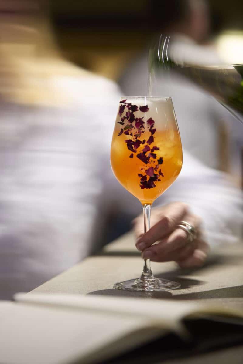 Cocktail servi dans un verre à pied au bar de l’Hôtel Village Montana à Tignes.