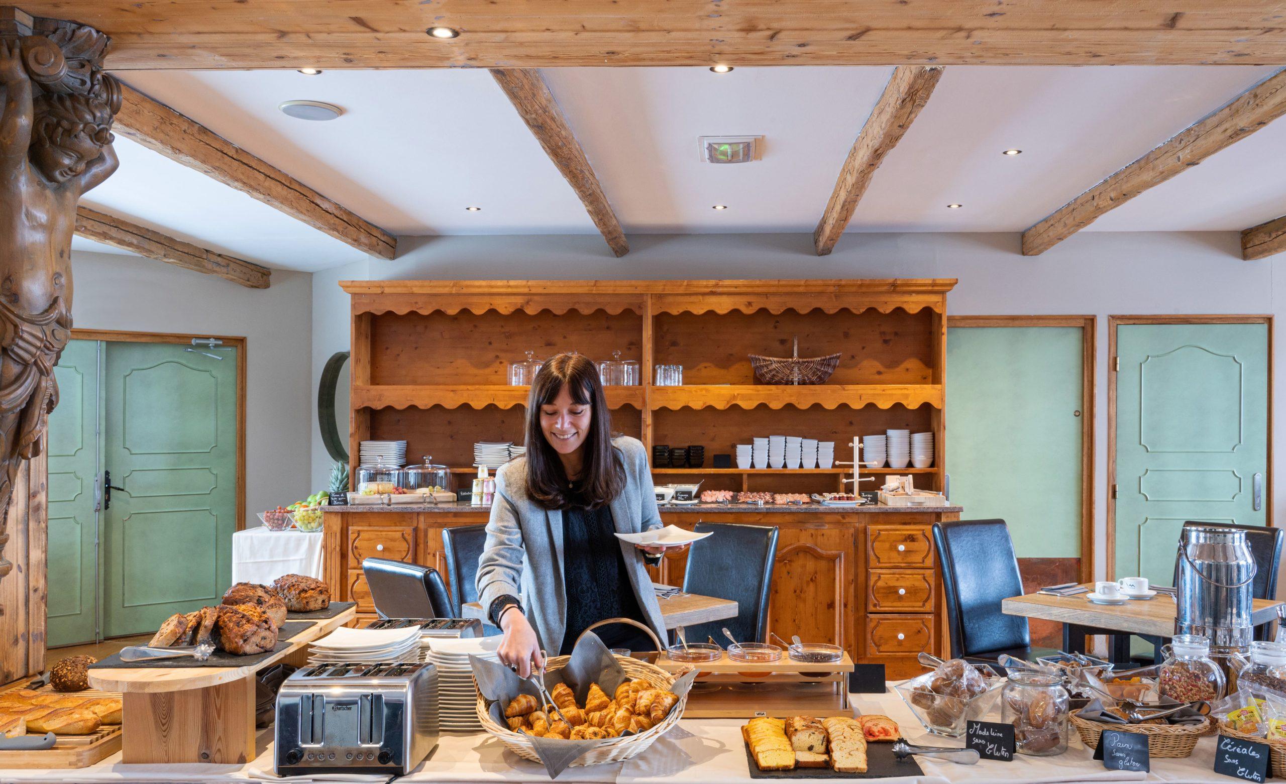 Buffet du petit-déjeuner au restaurant Le Gourmet des Suites du Montana, pains et viennoiseries sous les poutres.