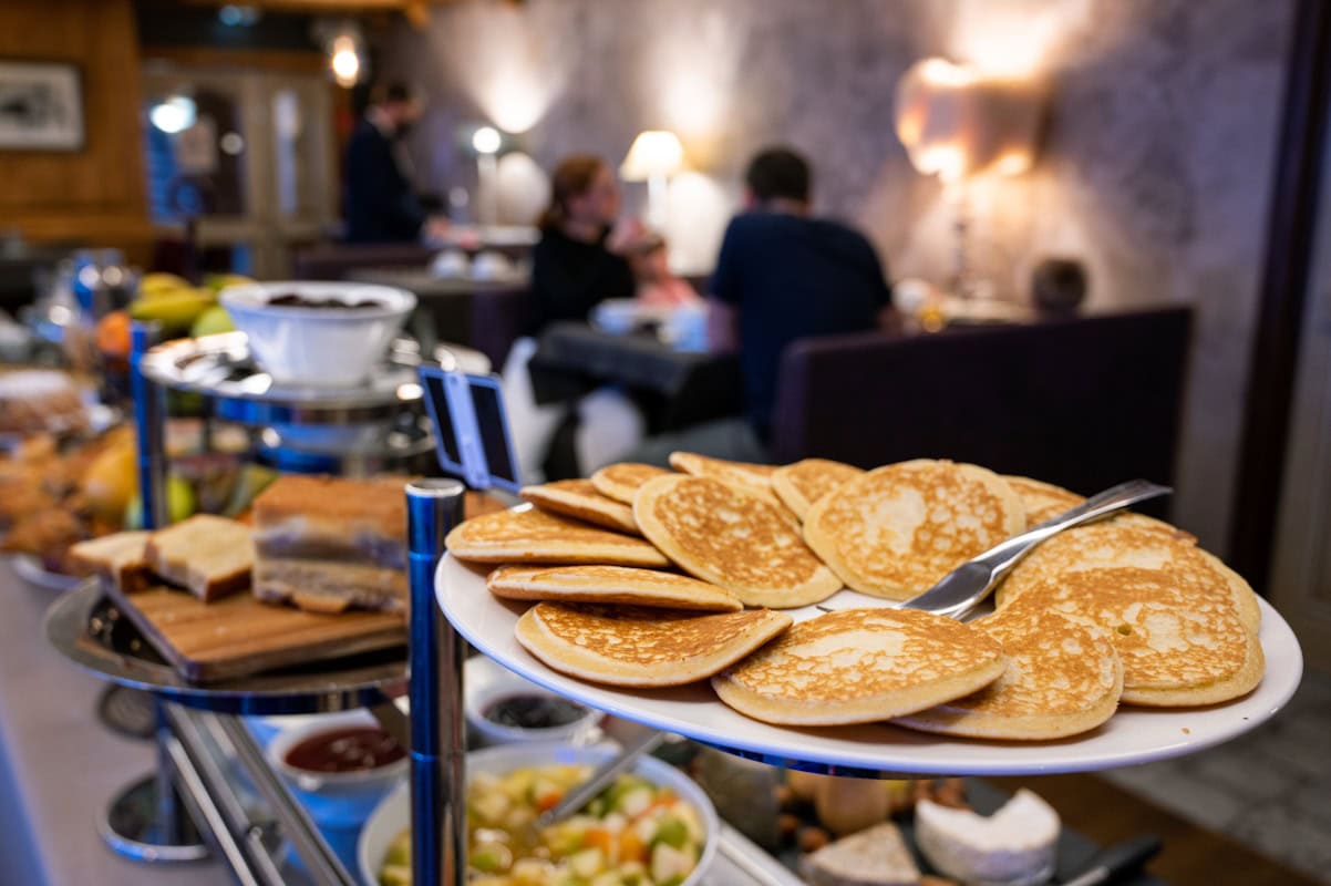 Pancakes, fruits et autres produits au buffet du petit-déjeuner des Campanules à Tignes.