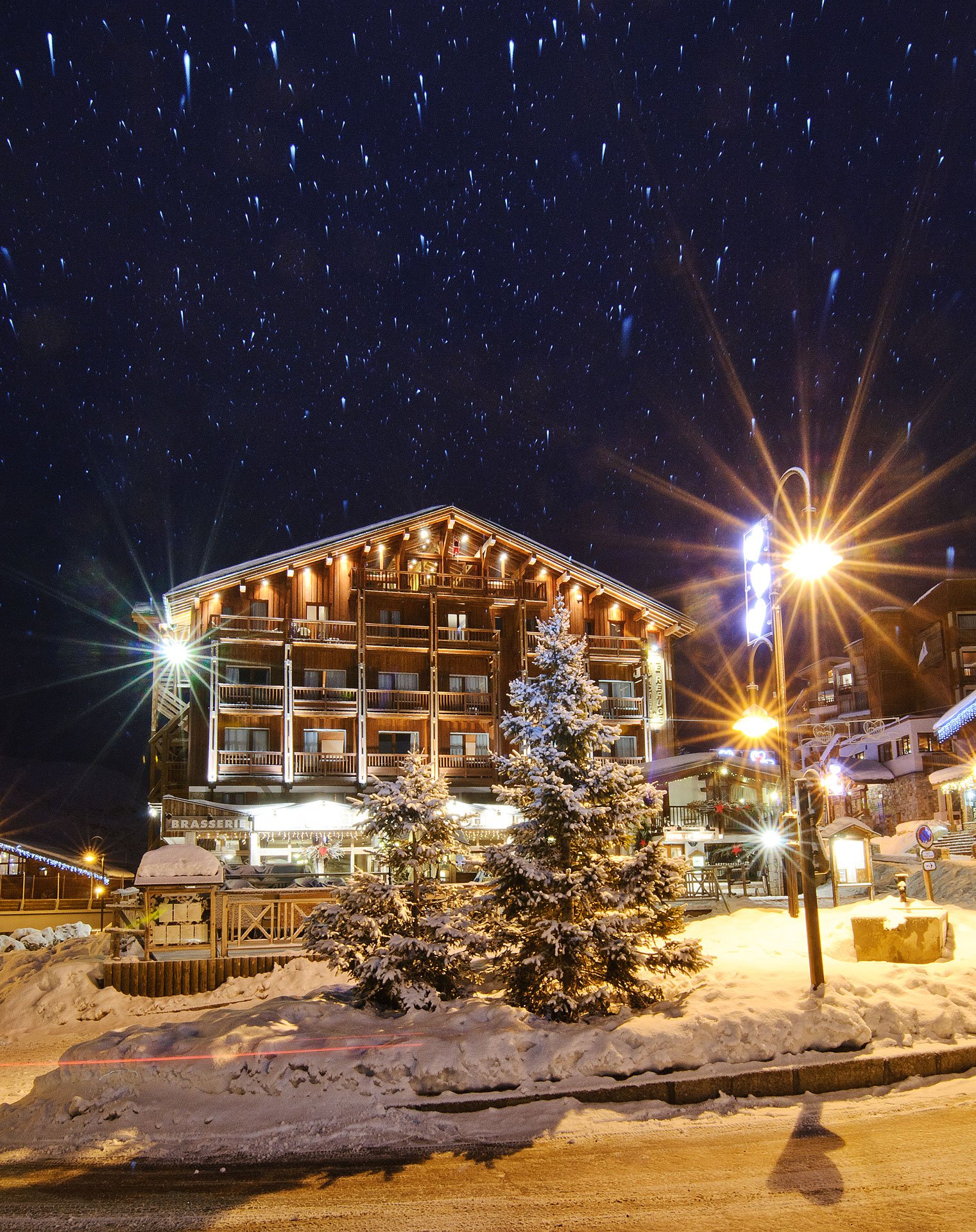 La façade du Refuge à Tignes le Lac, éclairée de nuit sous la neige.