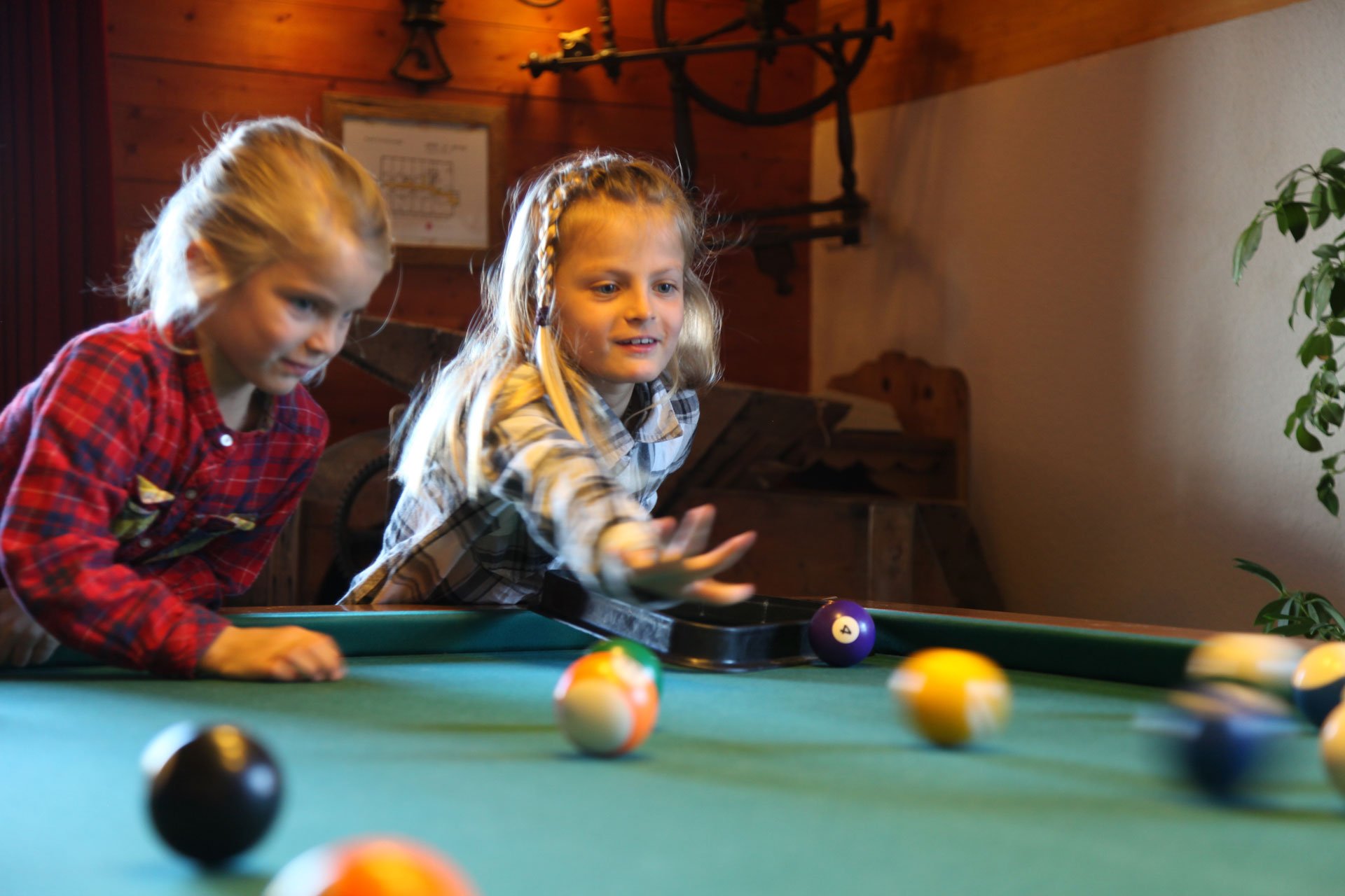 Deux enfants jouent au billard dans le salon du Refuge à Tignes.