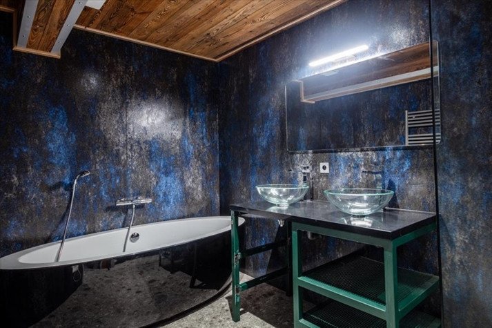 Salle de bains de la partie Charlie du Chalet Tango Charlie, avec baignoire noire et deux vasques en verre.