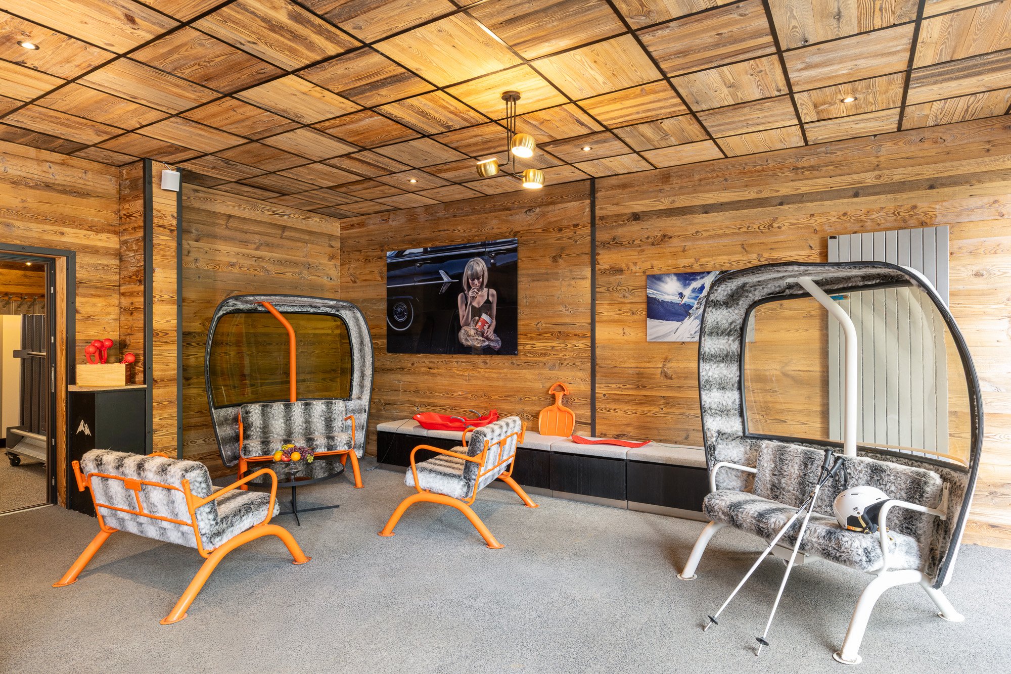 Salon partagé du Black Diamond à Tignes, avec banquettes dans des cabines de remontée mécanique et fauteuils.