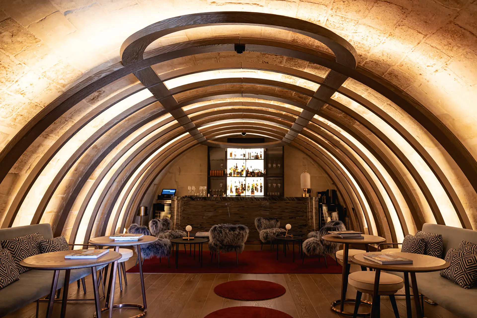 Salon voûté d'Iniala Harbour House à La Valette, avec fauteuils et éclairage suivant les arches.