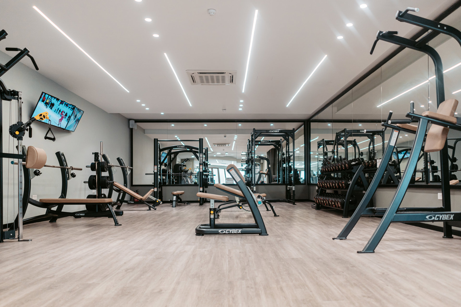Salle de sport du Corinthia Palace Malta, machines de musculation et bancs devant les miroirs.