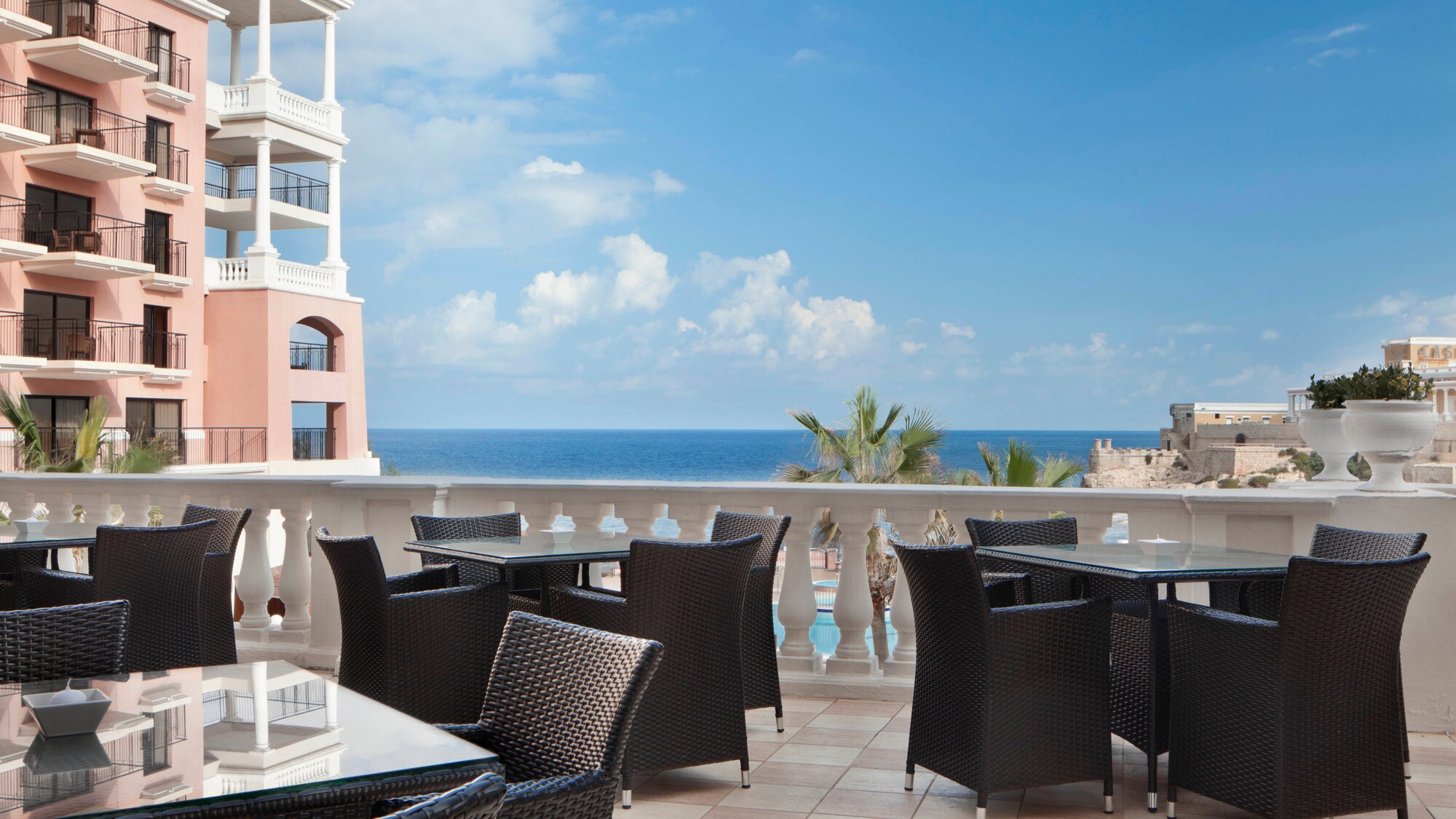 Terrasse de l'ORVM au Westin Dragonara Resort à Malte, fauteuils noirs devant la mer.
