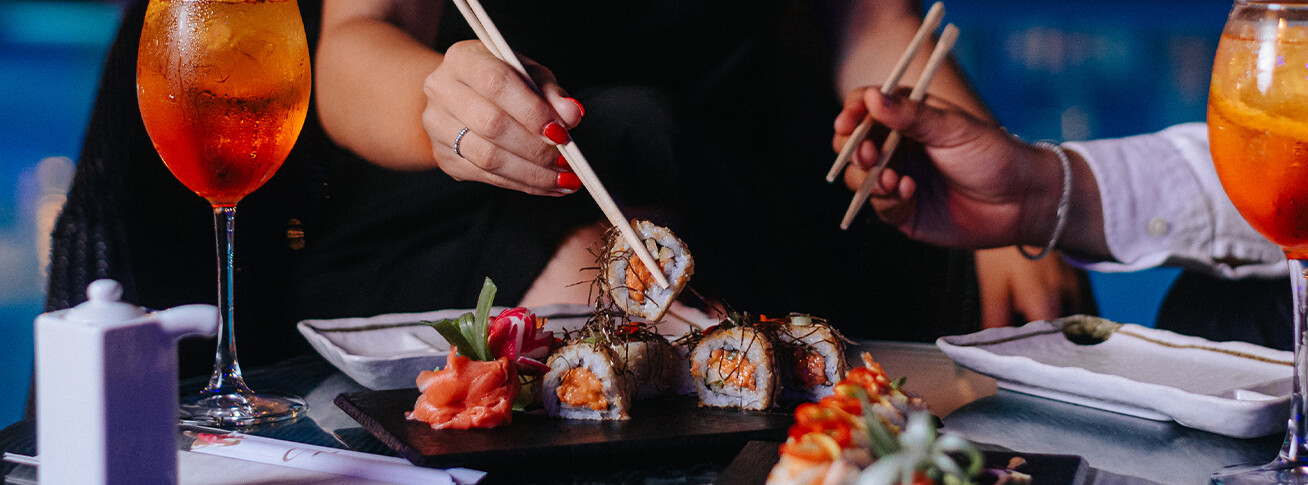 Sushis servis au Lounge 360 d'AX The Palace à Sliema, avec baguettes et cocktails sur la table.