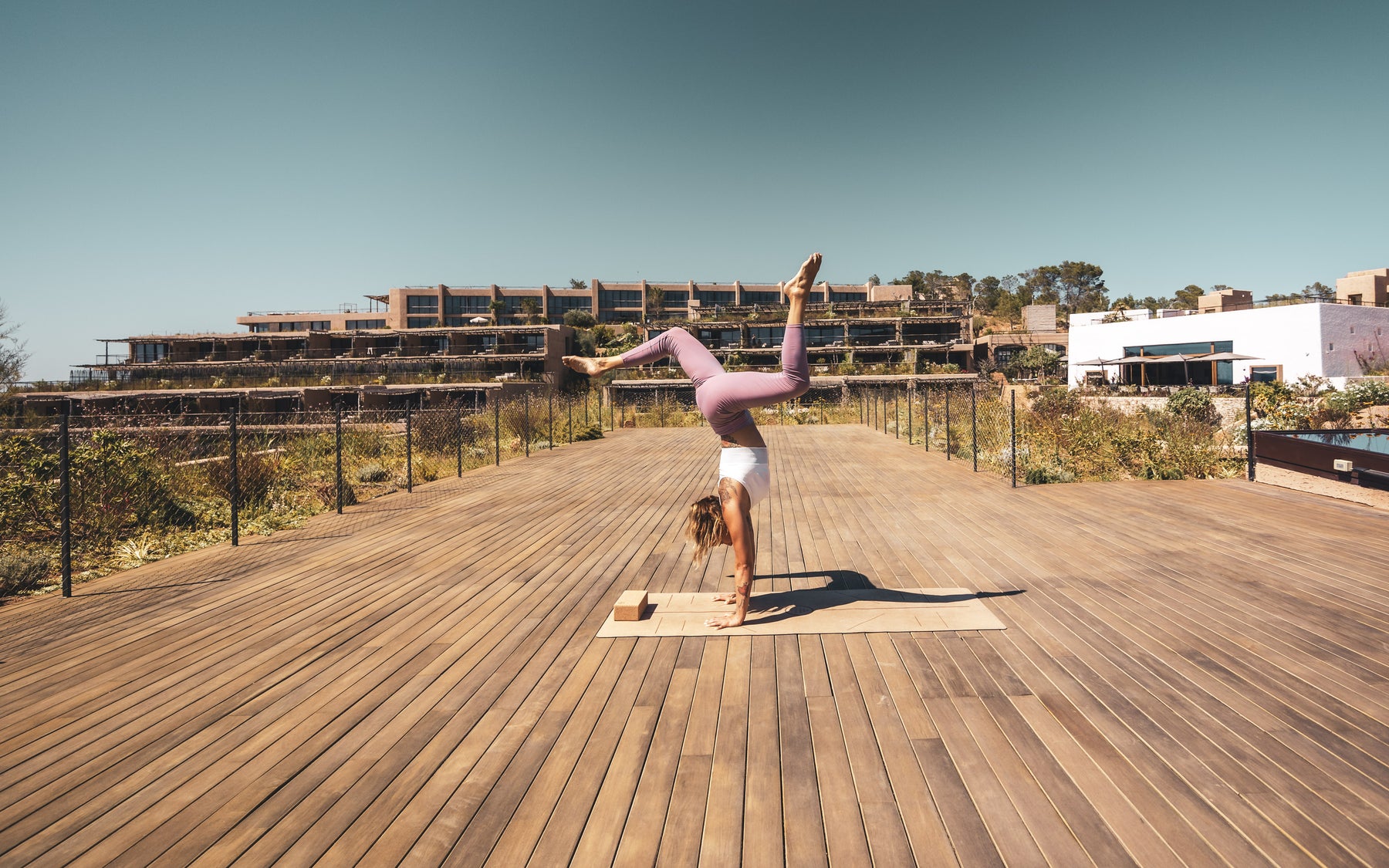 Pratique du yoga sur une grande terrasse en bois du Six Senses Ibiza.