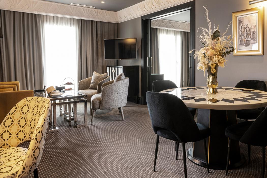 Salon de la Suite Art Déco du Casablanca Hotel, avec canapé, table ronde et fauteuils sombres.