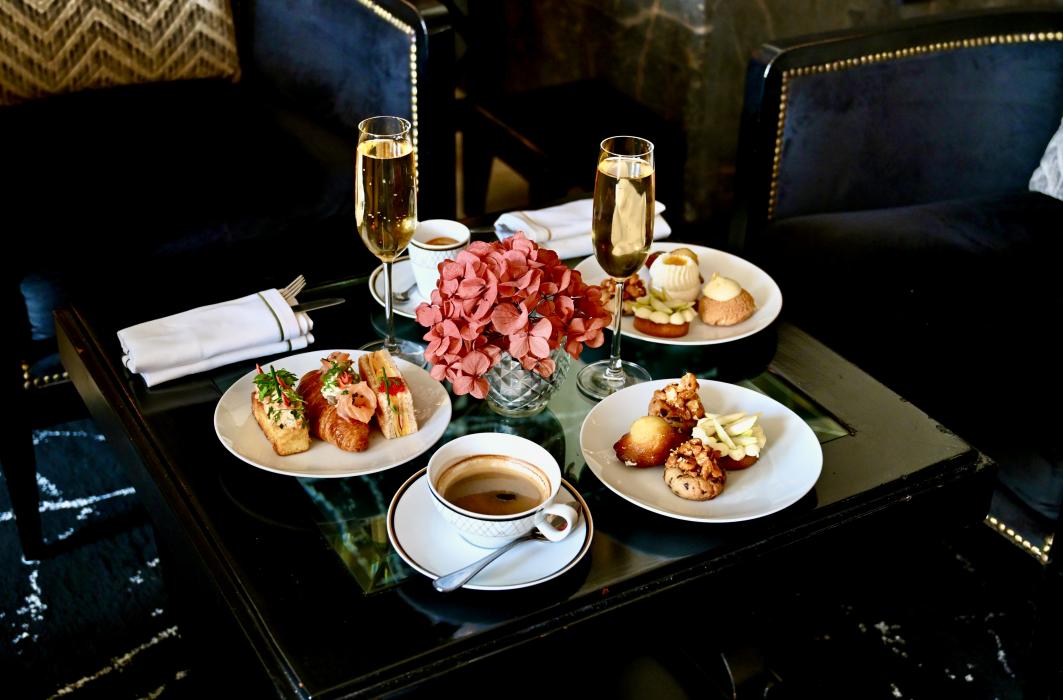Petites assiettes, boissons et fleurs roses sur une table du Lobby Lounge au Casablanca Hotel.
