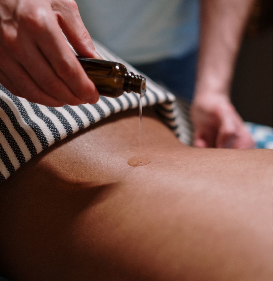 Huile versée sur le dos d'une personne pendant un massage au spa de l'Hôtel Le Doge à Casablanca.