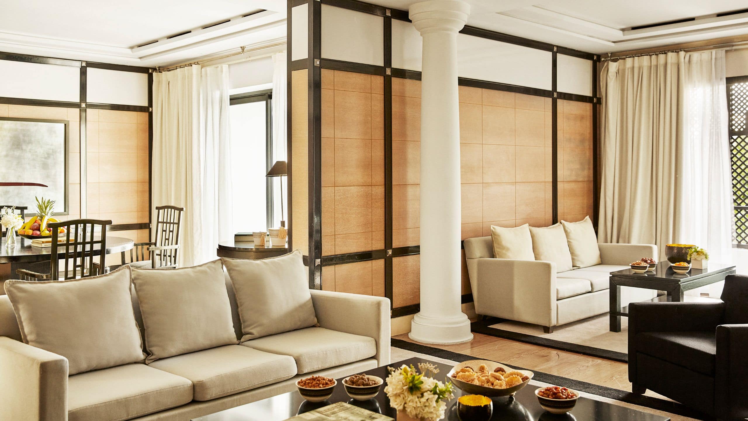 Salon de la suite Ambassador au Hyatt Regency Casablanca, avec canapés crème et panneaux de bois autour des espaces de réception.