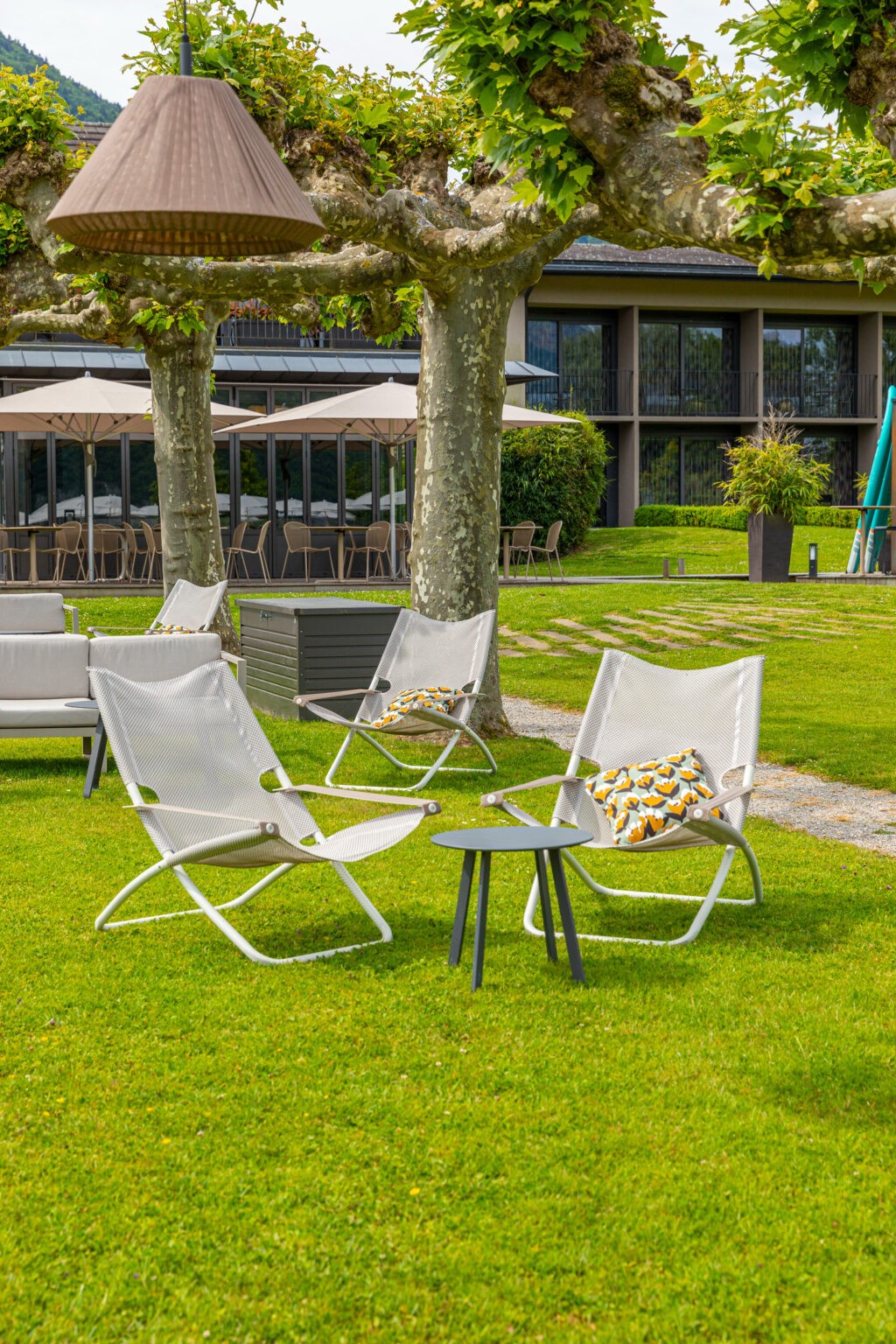 Fauteuils dans le jardin du Petit Létraz à Duingt, sous les arbres devant les chambres.
