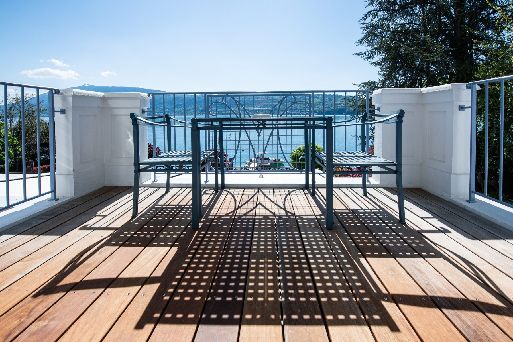 Balcon de La Maison Bleue par Yoann Conte, avec deux chaises et une table face au lac d'Annecy.