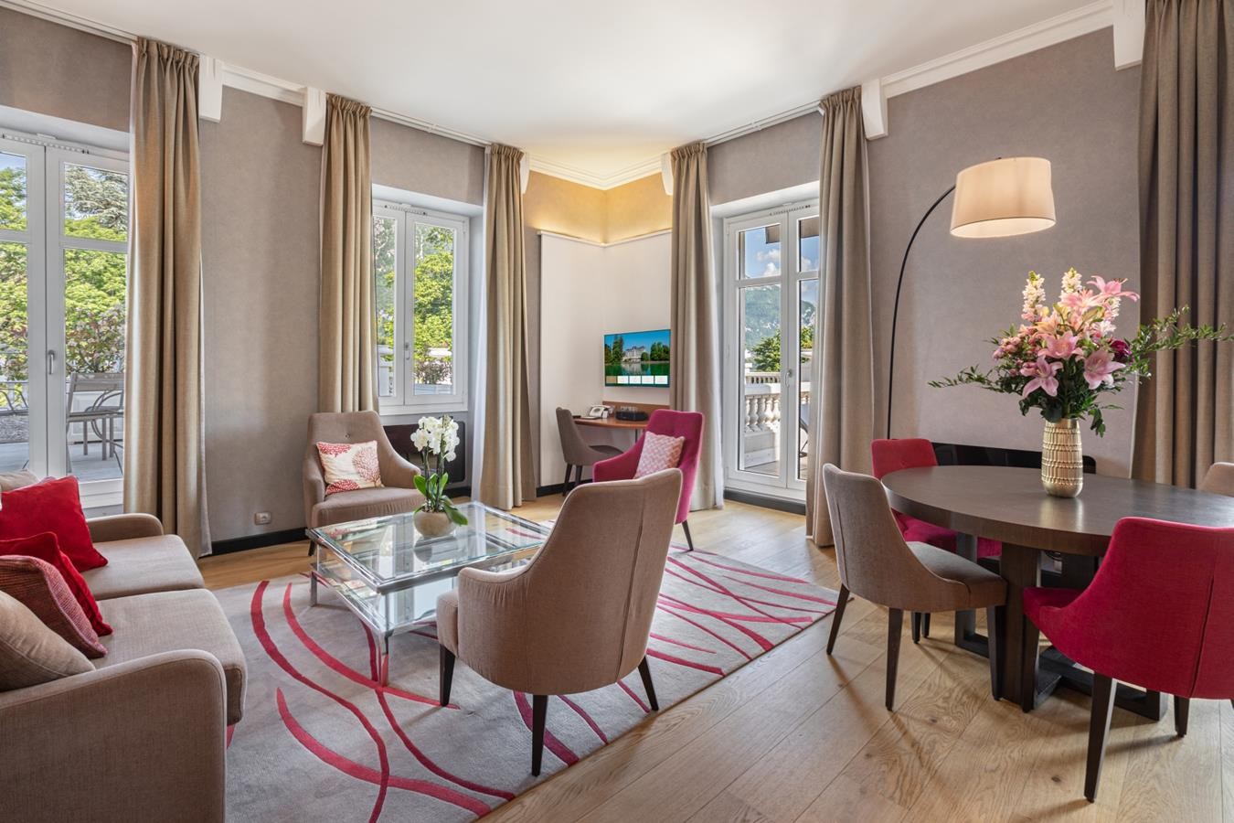 Salon d'une suite de l'Impérial Palace, avec canapé, fauteuils et table devant les fenêtres.