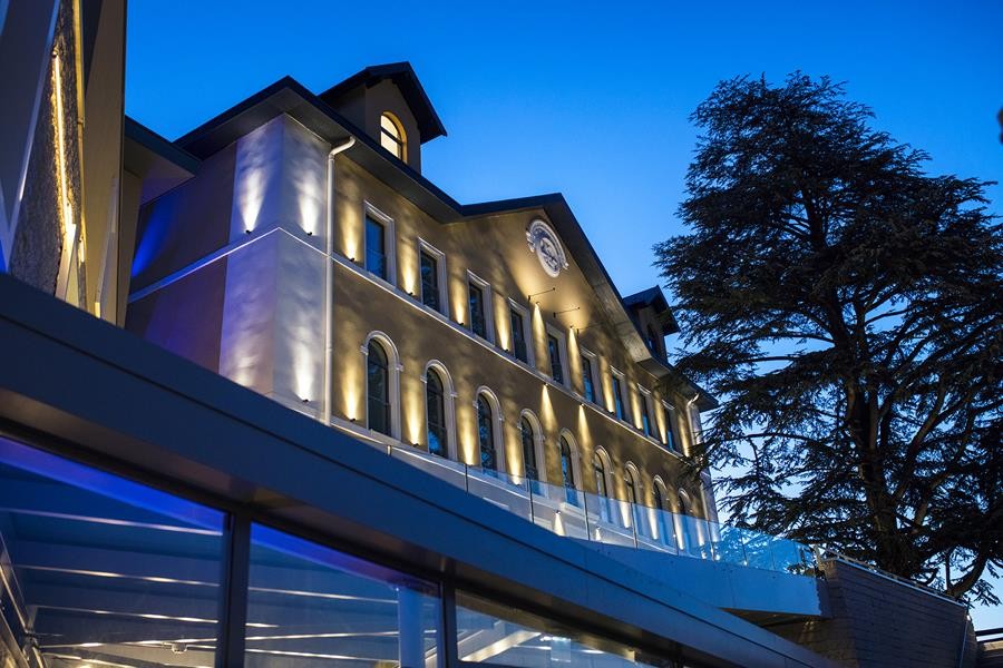 Façade historique éclairée de l'hôtel Le Pélican à Annecy, à côté du grand cèdre.