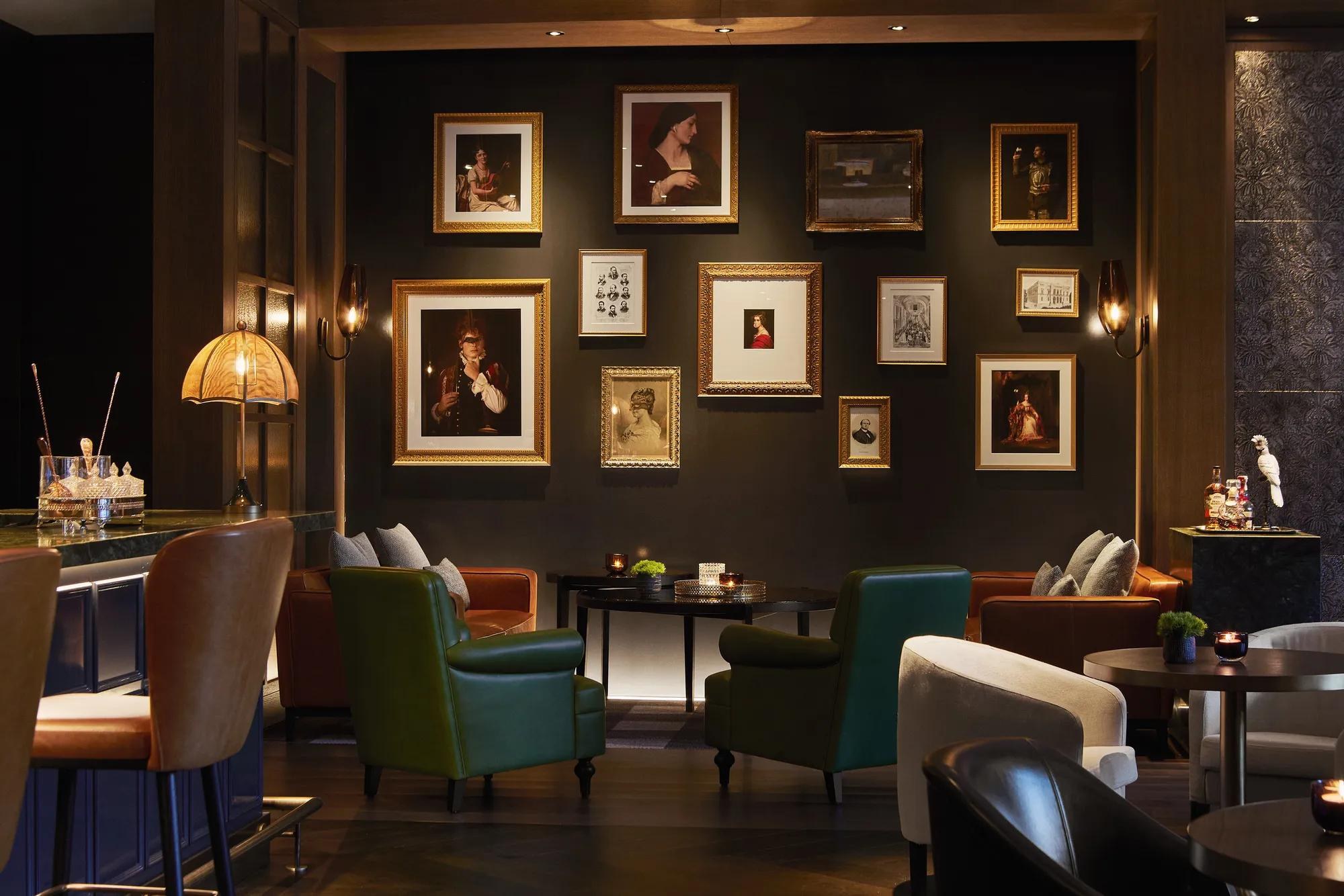 Un salon avec fauteuils et photographies - Rosewood Villa Magna à Madrid.