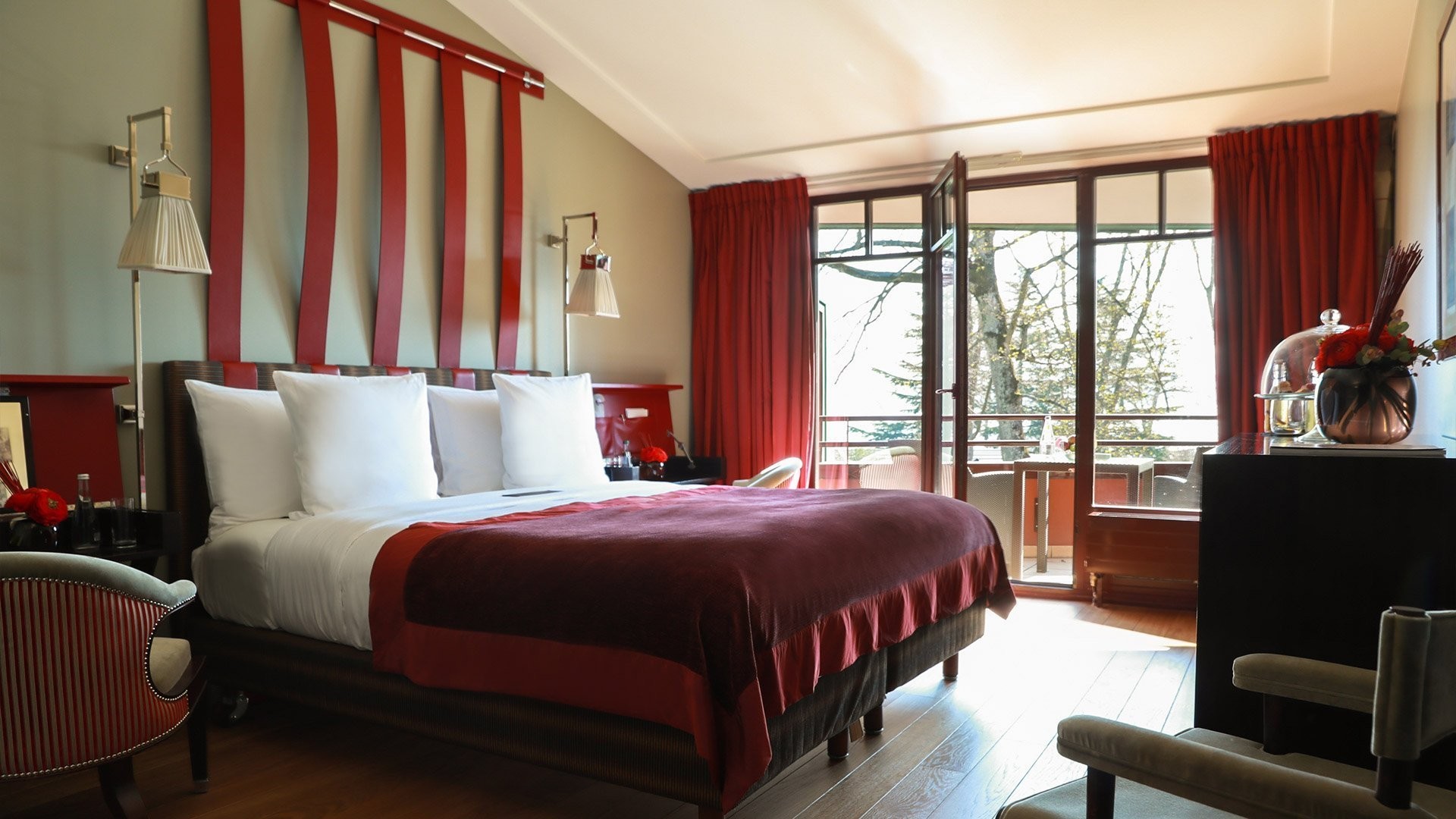 Chambre aux tissus rouges et tête de lit rayée - La Réserve Genève, Genève.