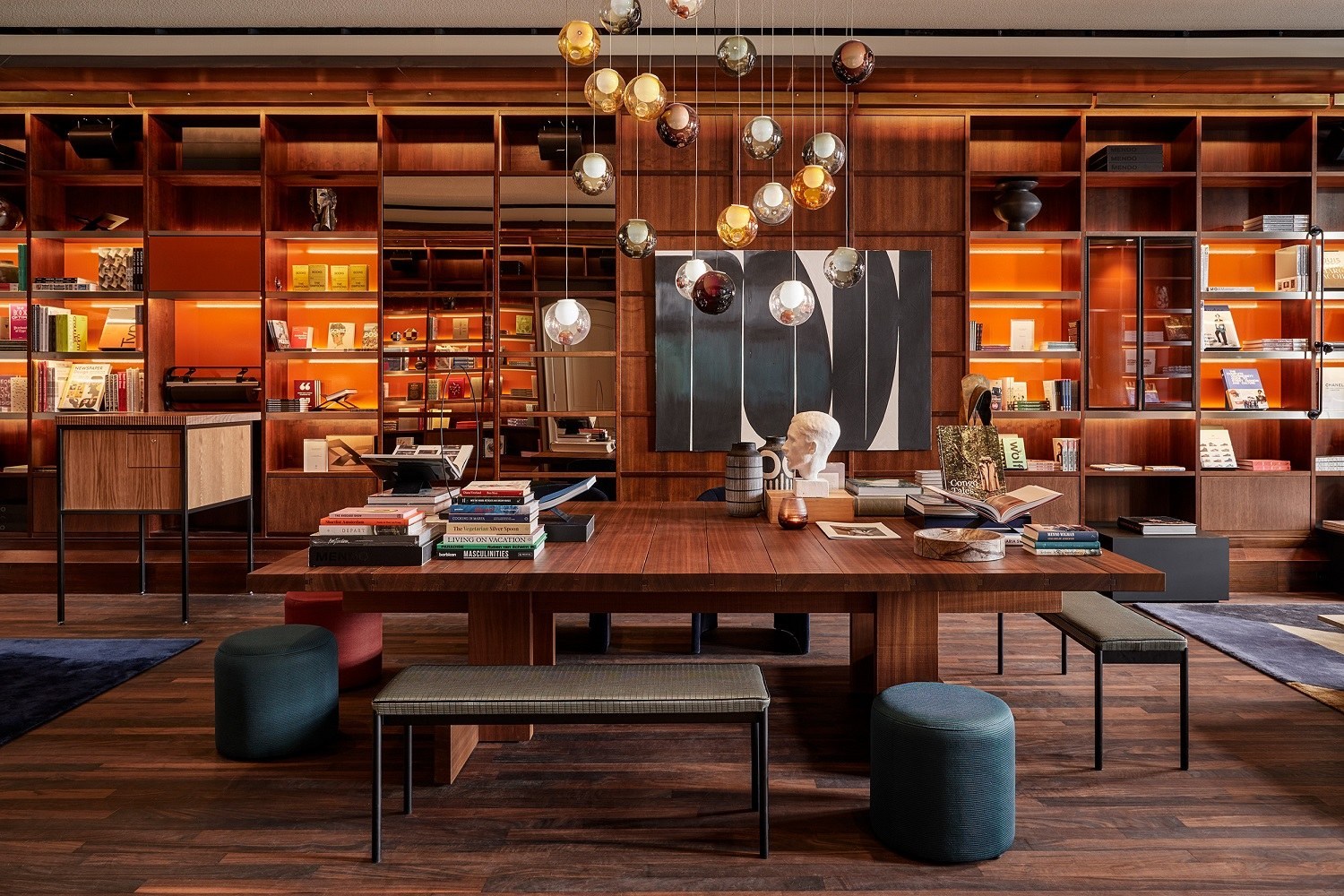 Un salon bibliothèque de De L’Europe Amsterdam, avec étagères et fauteuils