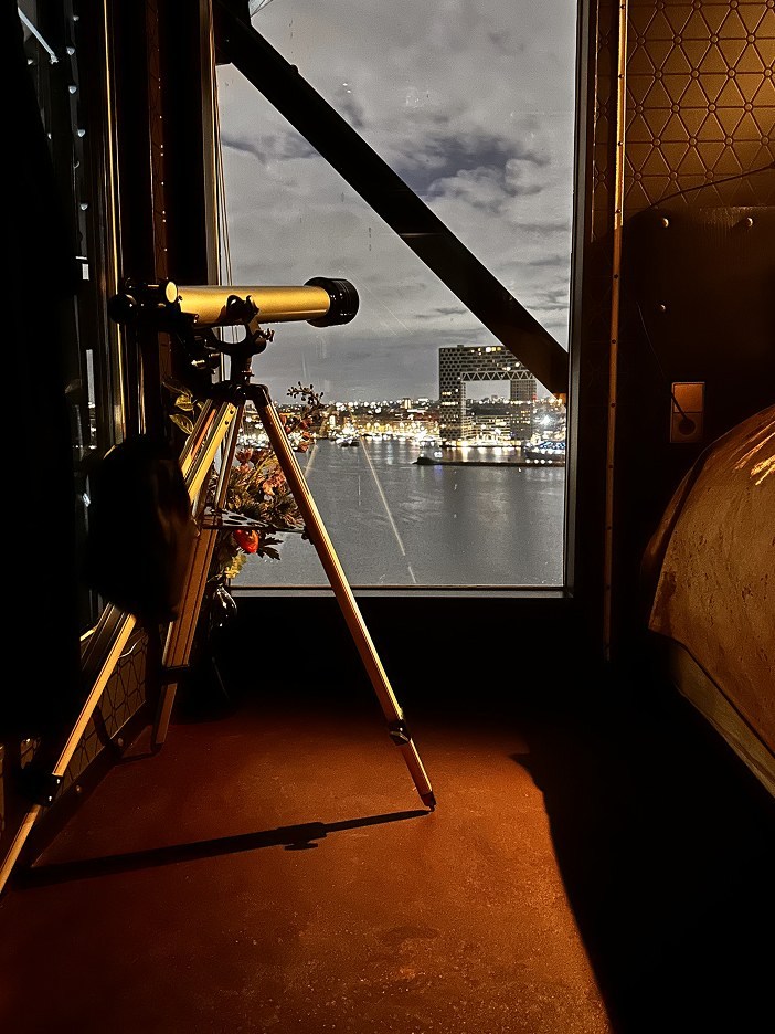Une longue-vue installée près d’une fenêtre au Faralda Crane Hotel Amsterdam