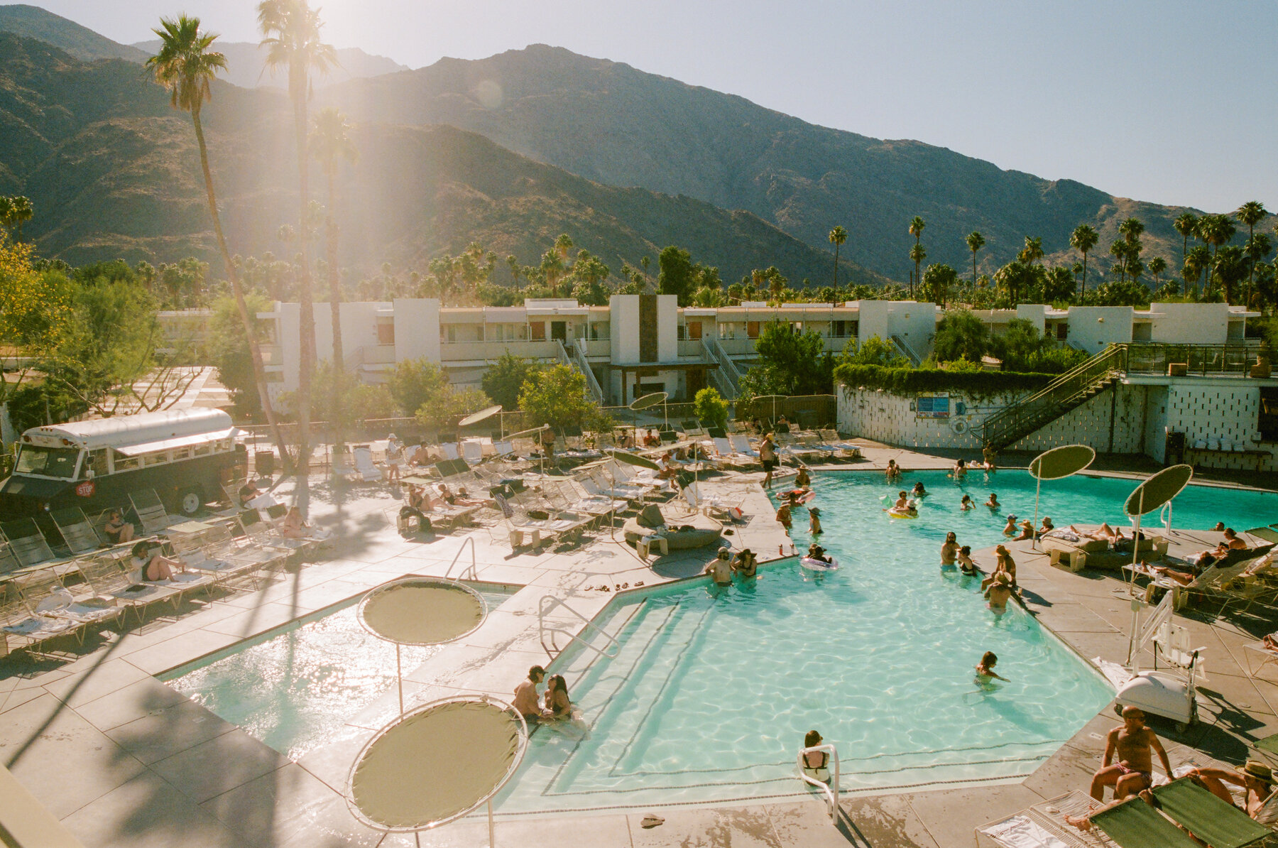 Vue plongeante sur les deux bassins du Swim Club, palmiers et monts San Jacinto