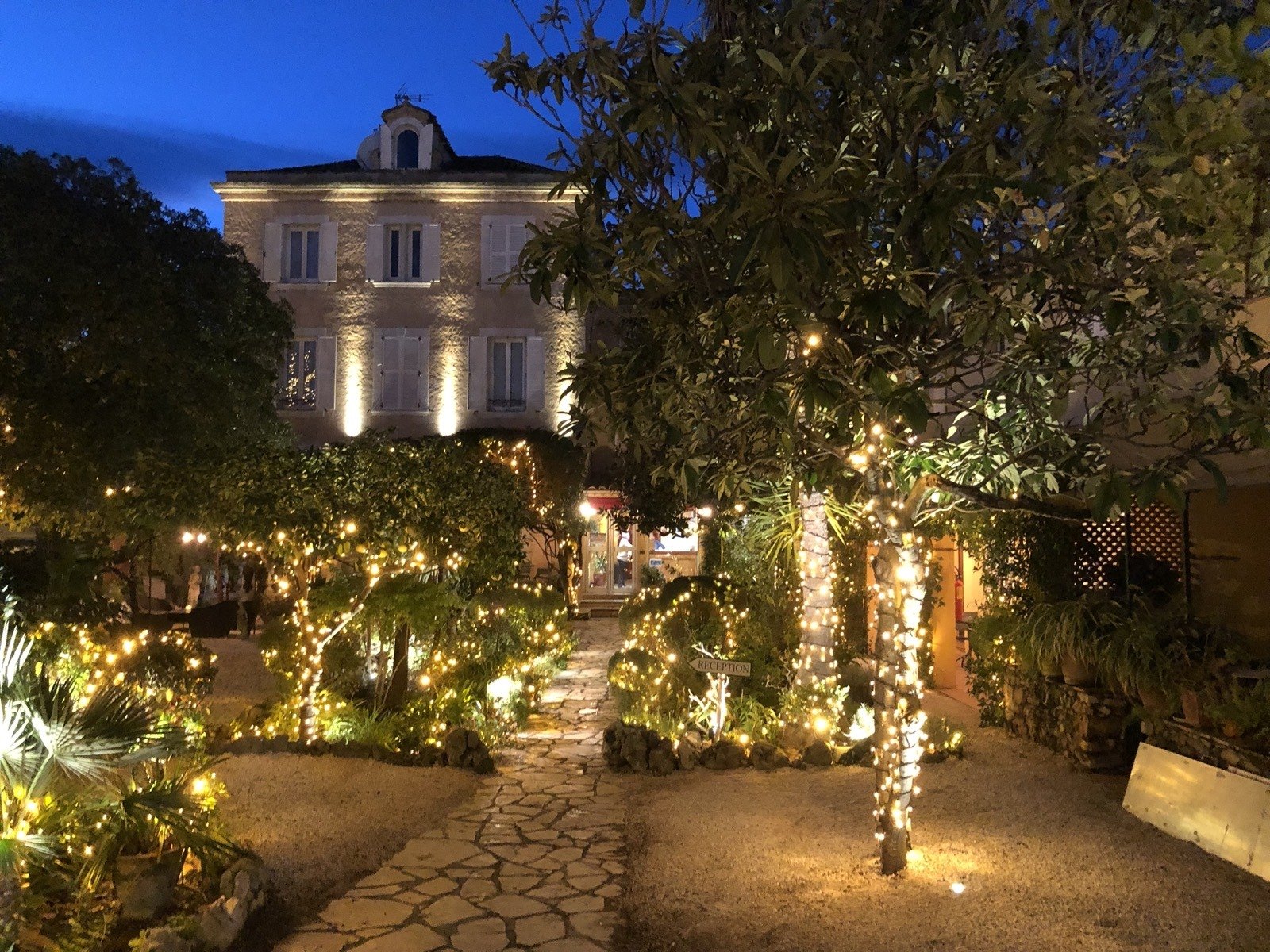 La bâtisse des Palmiers et son jardin illuminés à la nuit tombée, à Saint-Tropez