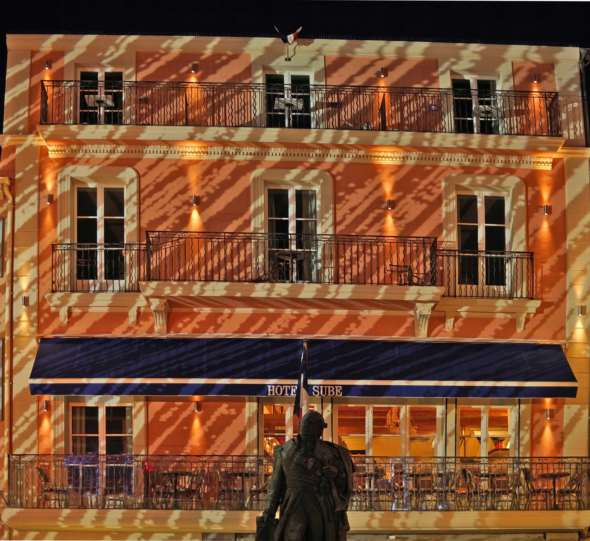 La façade éclairée du Sube et son enseigne, sur le port de Saint-Tropez