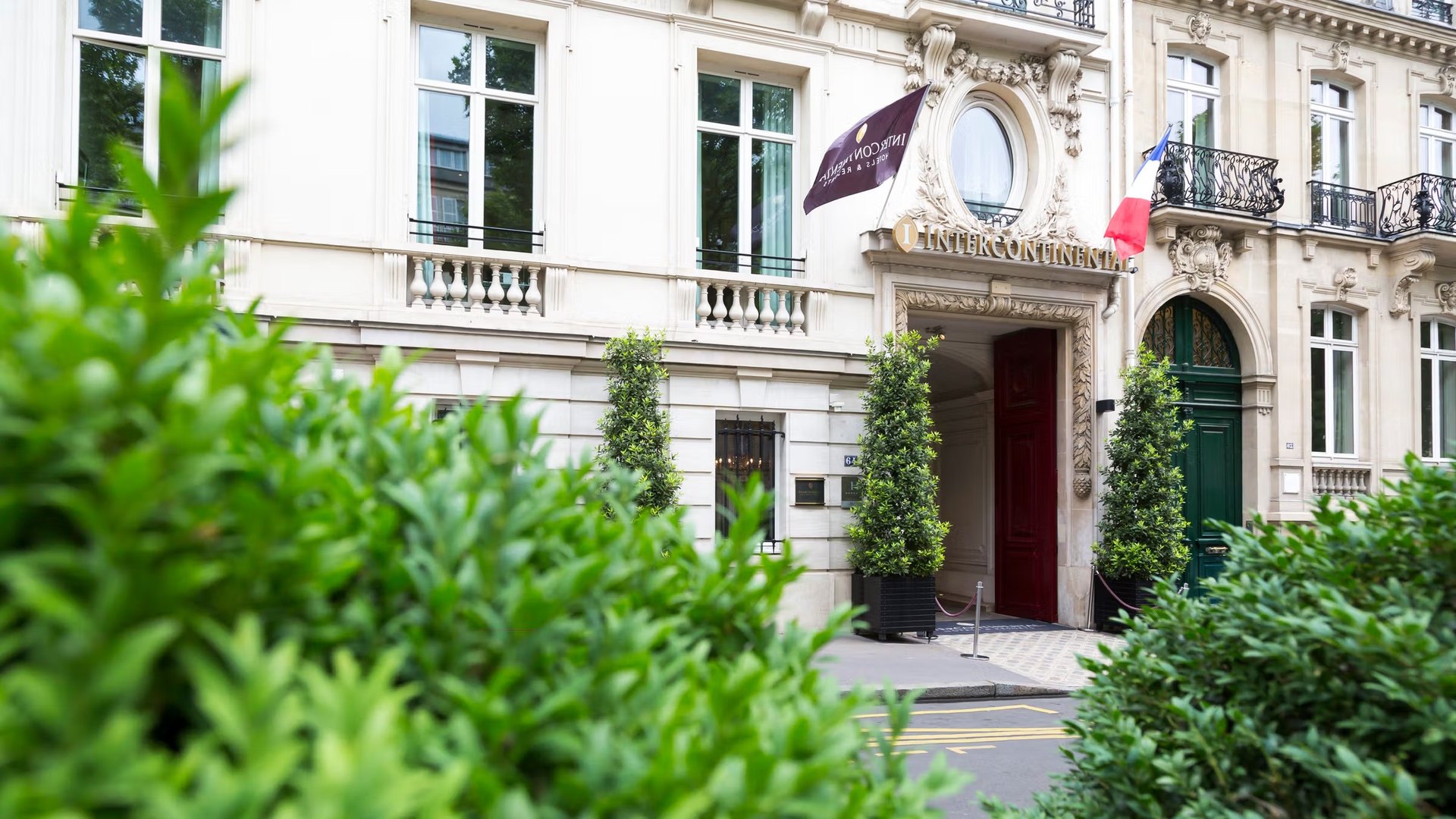 Le porche d'entrée du 64 avenue Marceau, son enseigne dorée et le drapeau français