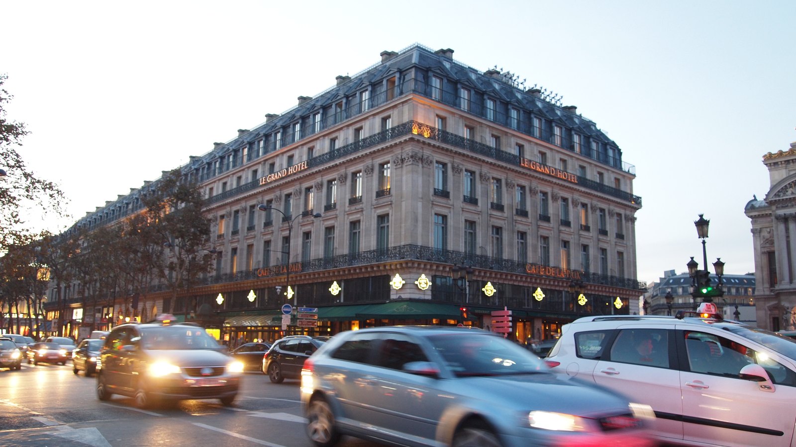 Les stores verts du Café de la Paix sous la façade de l'hôtel