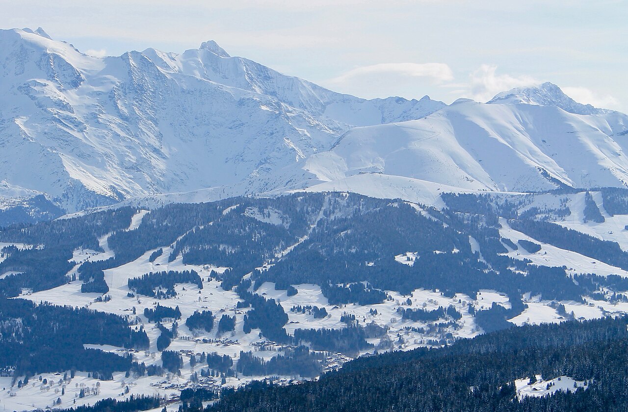 Les pistes et les chalets du Mont d'Arbois en hiver, devant de hauts sommets enneigés