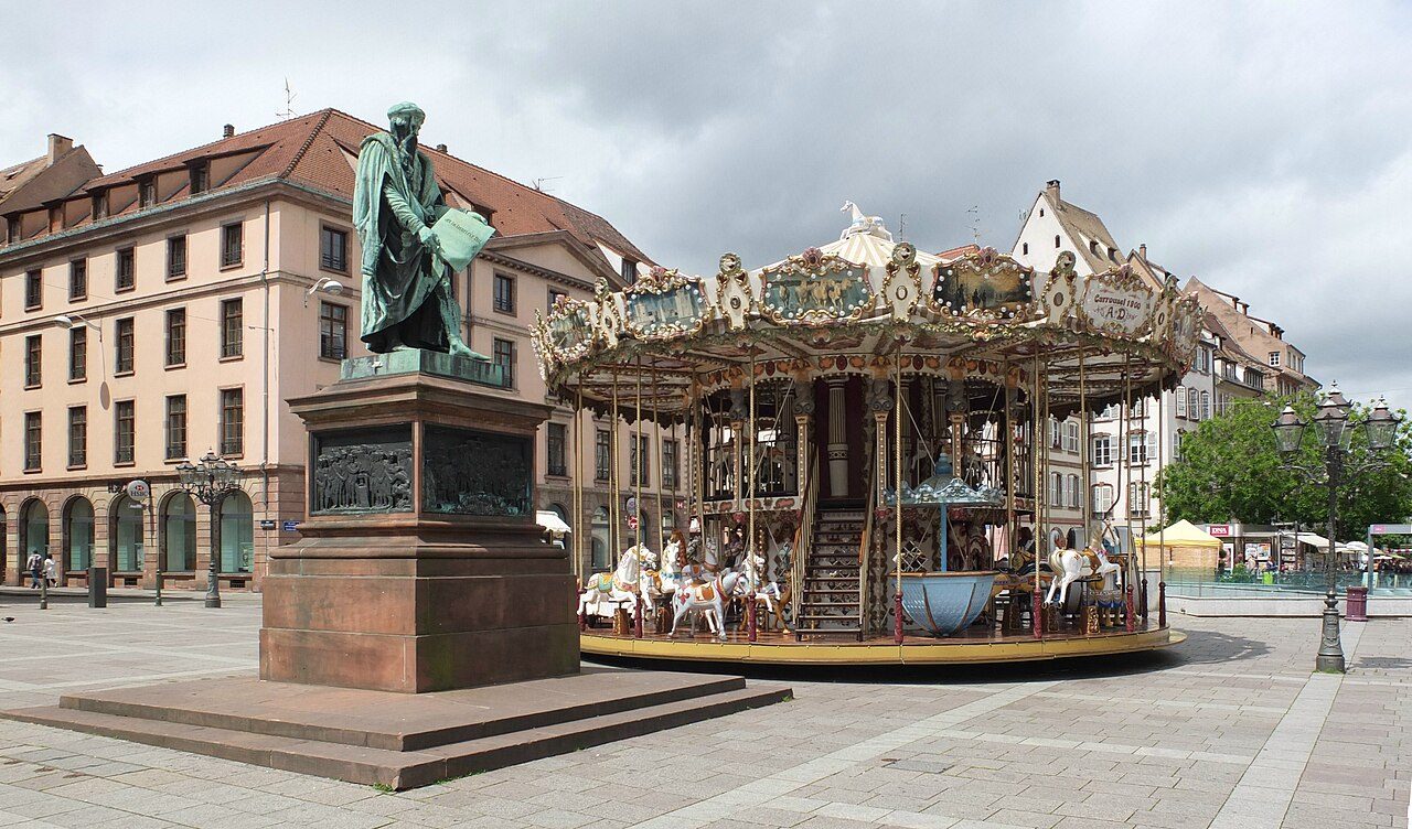 La place Gutenberg, sa statue de Gutenberg et son carrousel, au cœur de la Grande Île