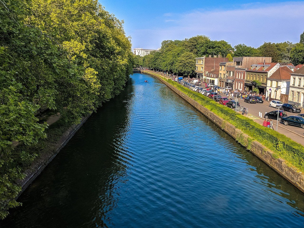 Le canal qui longe la Citadelle, entre les arbres du parc et une rangée de maisons et de terrasses