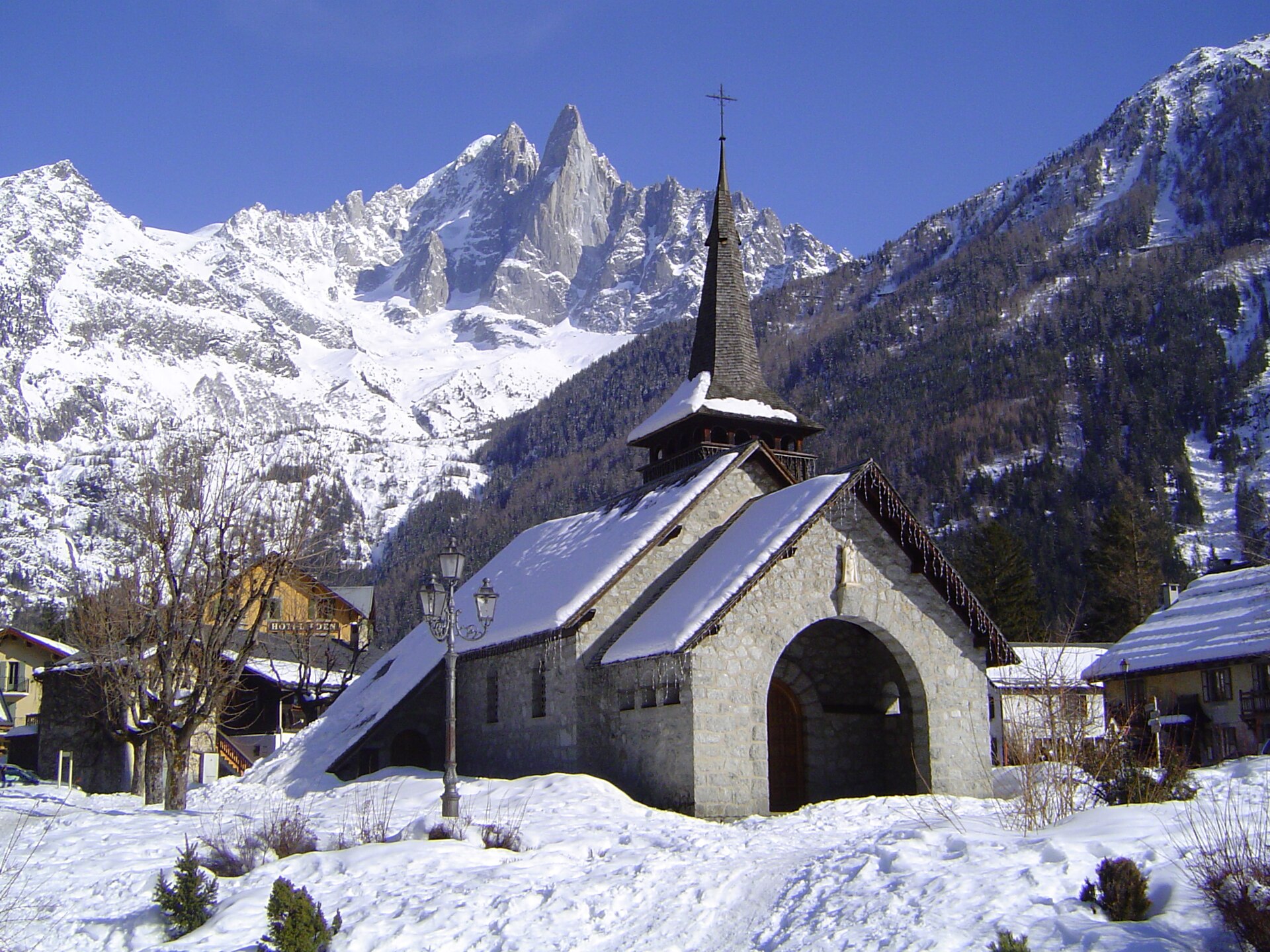 L'église des Praz-de-Chamonix sous la neige, avec l'aiguille du Dru en arrière-plan