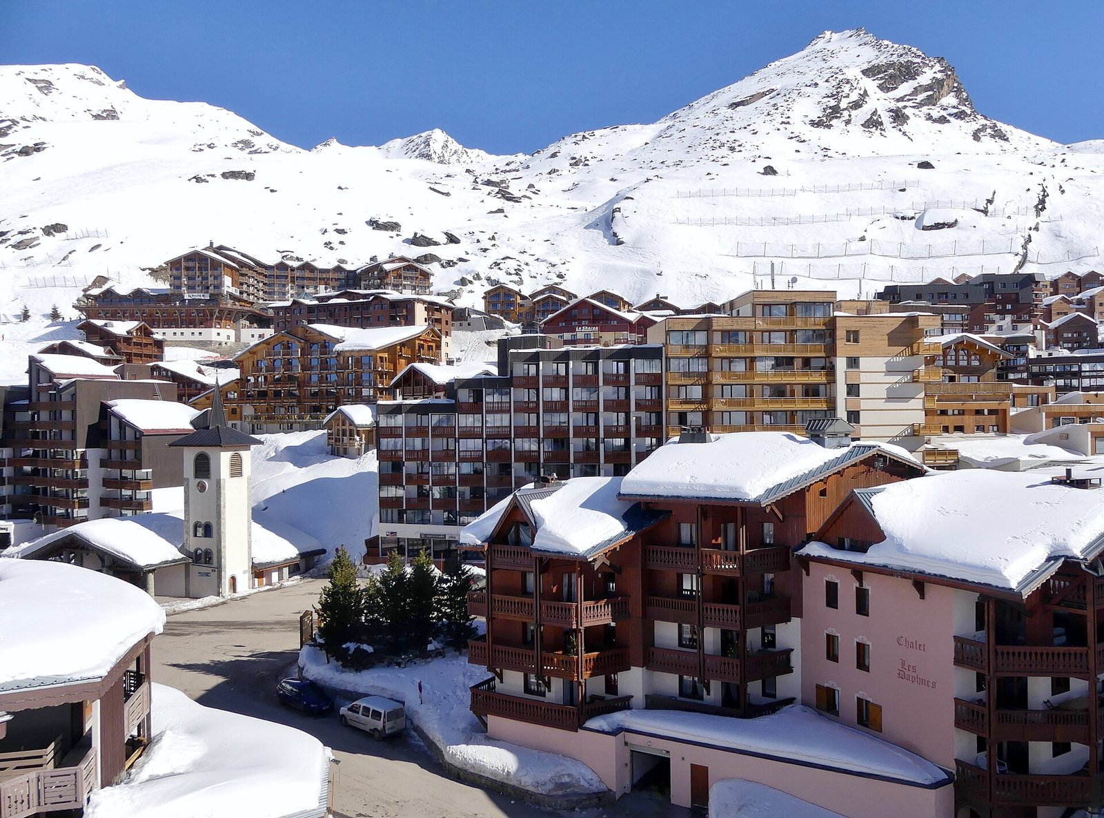 Le haut de Val Thorens en février 2019, vu depuis un télésiège : les façades en bois du Koh-I Nor et du Sherpa dominent le clocher de la chapelle.