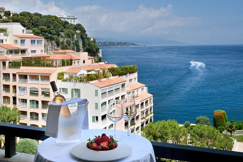 Table dressée sur un balcon du Columbus Monte-Carlo, avec vue sur la mer et les immeubles de Fontvieille à Monaco