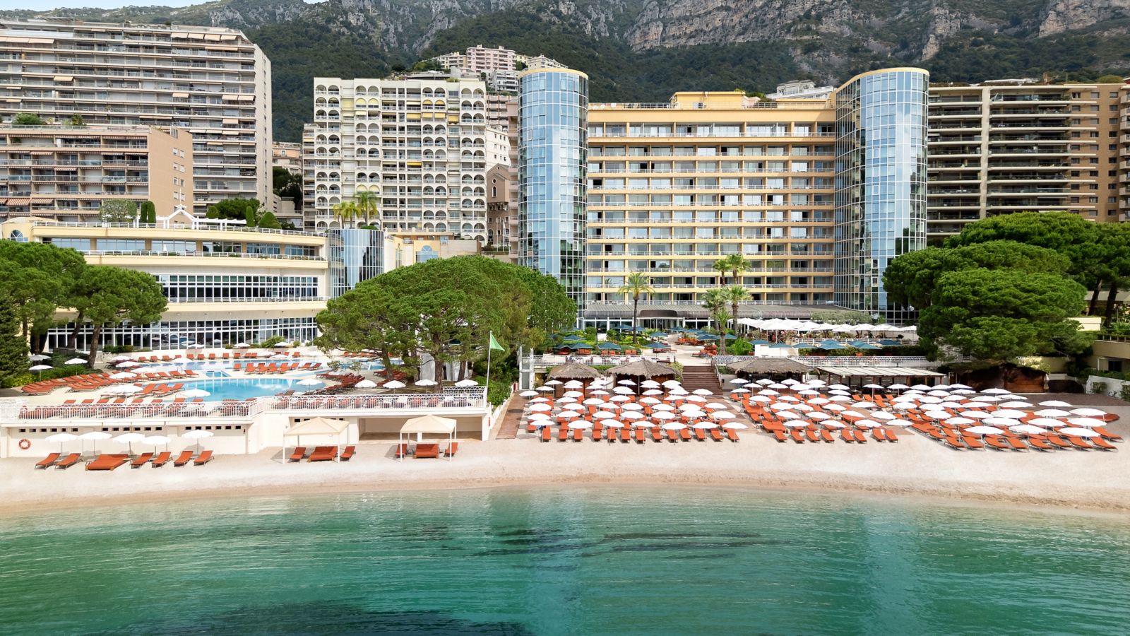 Le Méridien Beach Plaza vu de la mer, sa plage privée, ses parasols et ses tours de verre au Larvotto, Monaco
